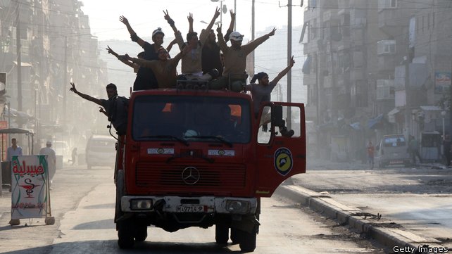 Syrian civil defence volunteers known as the White Helmets celebrate after rebels said they have broken a three-week government siege on Aleppo