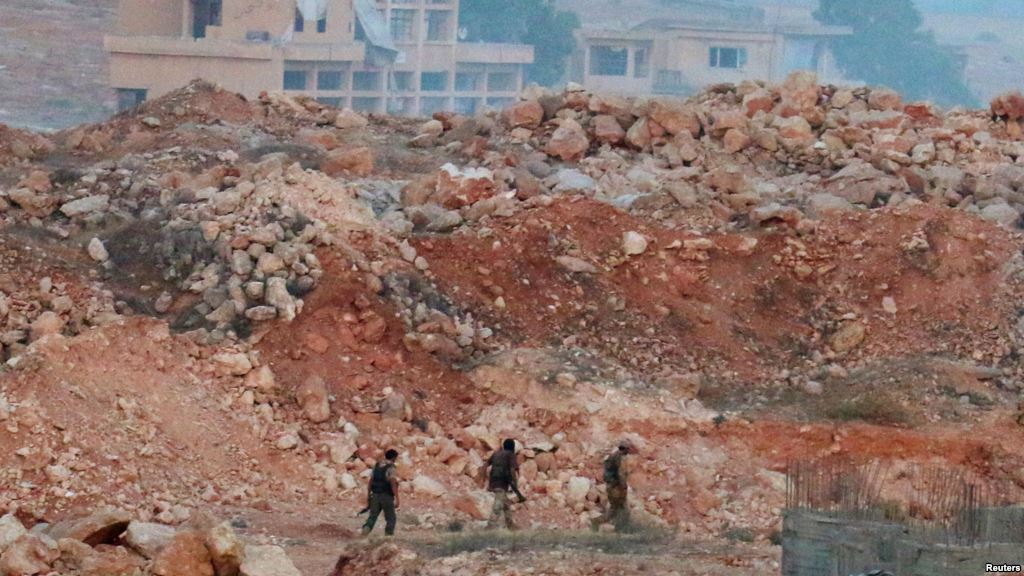 Fighters from the Syrian Islamist rebel group Jabhat Fateh al-Sham the former Al Qaeda-affiliated Al-Nusra Front patrol amid the rubble in southwestern Aleppo Syria on August 5