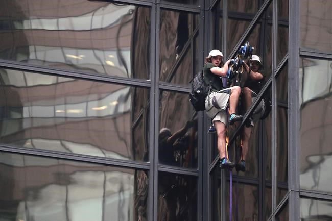 A man scales the all-glass facade of Trump Tower using suction cups Wednesday Aug. 10 2016 in New York. A police spokeswoman says officers responded to Donald Trump's namesake skyscraper on Fifth Avenue in Manhattan. The 58-story building is headqu