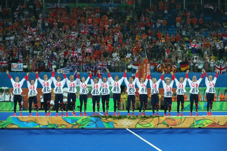 Team GB's women hockey players celebrate their Olympic gold medals on the Rio podium