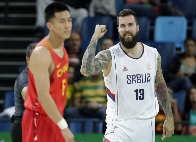 Serbia's Miroslav Raduljica celebrates in front of China's Guo Ailun left after making a basket during a basketball game at the 2016 Summer Olympics