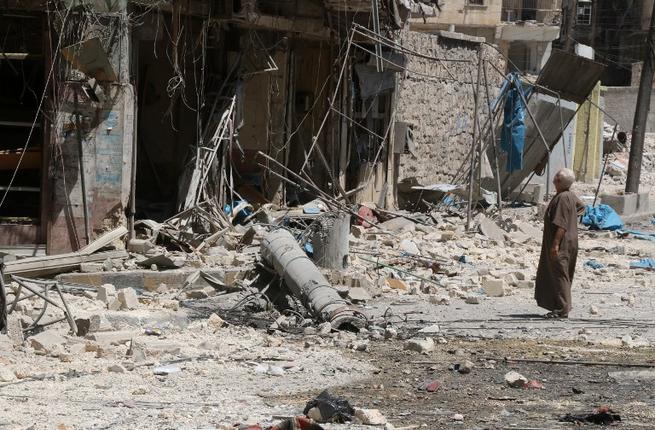 A resident of the Tariq al Bab neighborhood of Aleppo inspects the damage caused by reported air raids that targeted rebel-held areas in the northern city