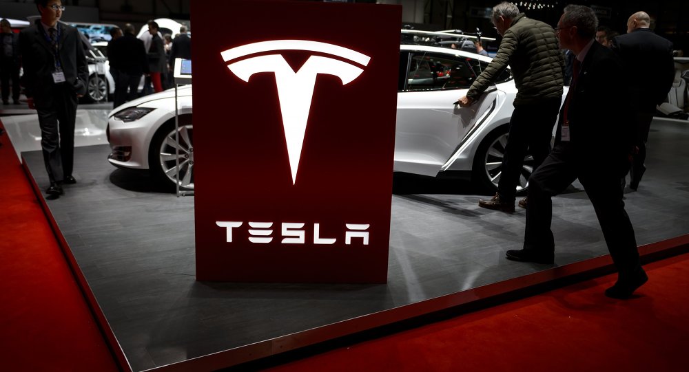 Visitor are seen at the booth of US electric carmaker Tesla Motors during the press day of the Geneva Car Show