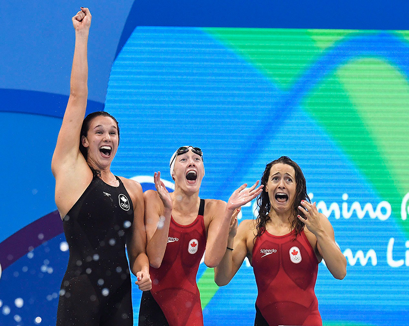 The Canadian women's 4x100-metre freestyle relay team celebrates their bronze medal finish while Penny Oleksiak completes the relay at the 2016 Summer Olympics in Rio de Janeiro Brazil Saturday Aug. 6 2016