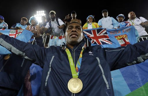 Viliame Mata of Fiji poses with fans after winning the gold medal match against Britain in the mens rugby sevens at the 2016 Summer Olympics in Rio de Janeiro Brazil Thursday Aug. 11 2016