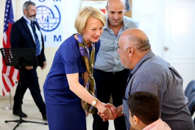 The U.S. ambassador to Jordan Alice Wells shakes hands with Syrian refugees ahead of their departure to the United States on Sunday