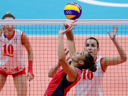 The USA's Alisha Glass prepares to set up a teammate with Serbia middle blocker Milena Rasic looming