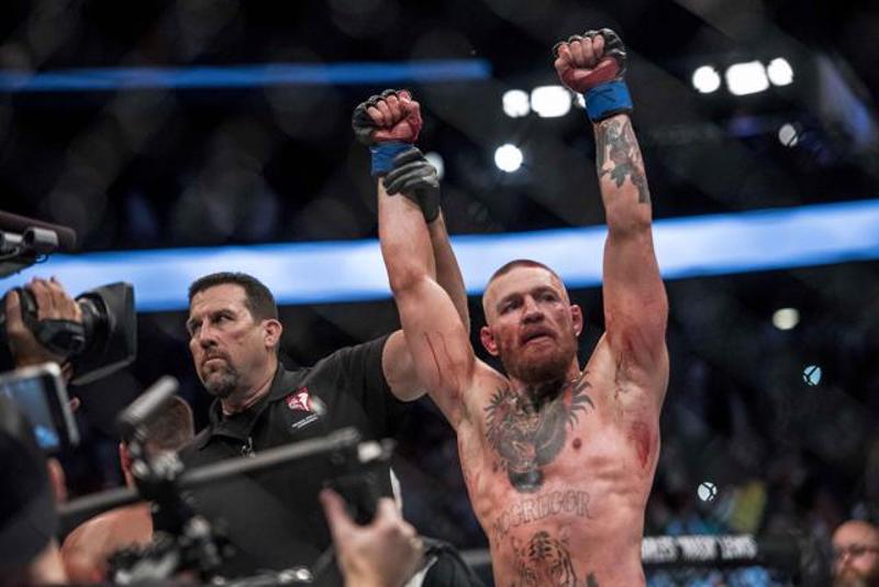 The referee lifts McGregor’s hands to indicate the winner