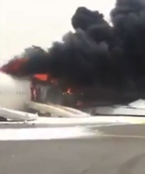 Thick black plumes of smoke are seen billowing out of the aircraft