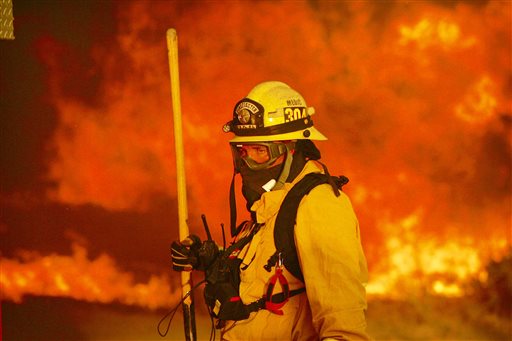 A firefighter prepares to battle a wildfire in the Cajon Pass in San Bernardino county Calif. on Tuesday. The wildfire that began as a small midmorning patch of flame next to Interstate 15 in the Cajon Pass had by Wednesday afternoon turned into a 47-sq