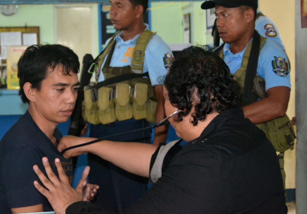 A doctor is seen Wednesday with rescued Mohammad Safyan left. The Philippine government says it has stepped up its offensive against militants