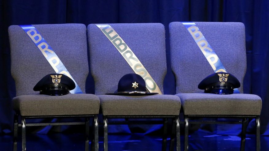 Three chairs honoring the slain Baton Rouge police officers are seen on stage at memorial service at Healing Place Church