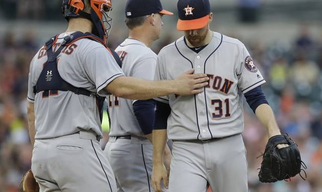 Houston Astros catcher Evan Gattis pats starting pitcher Collin Mc Hugh on the chest after being pulled during the second inning of a baseball game against the Detroit Tigers Friday