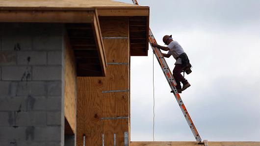 A construction worker climbs on the roof of a home in Boca Raton Florida