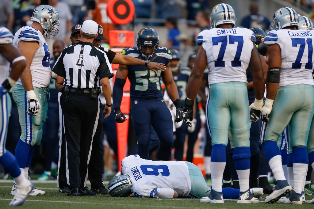 SEATTLE WA- AUGUST 25 Quarterback Tony Romo #9 of the Dallas Cowboys lies on the turf after being injured in the first quarter during a preseason game against the Seattle Seahawks at Century Link Field