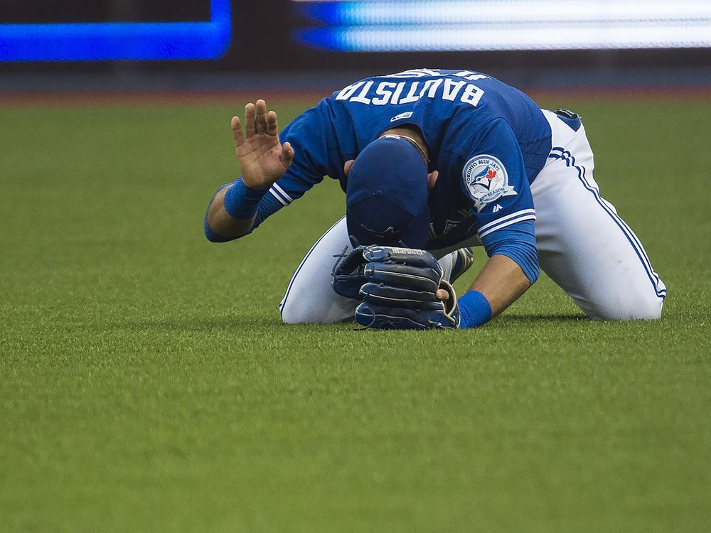 Toronto Blue Jays right fielder Jose Bautista reacts after tripping over the turf in the third inning of Tuesday's game