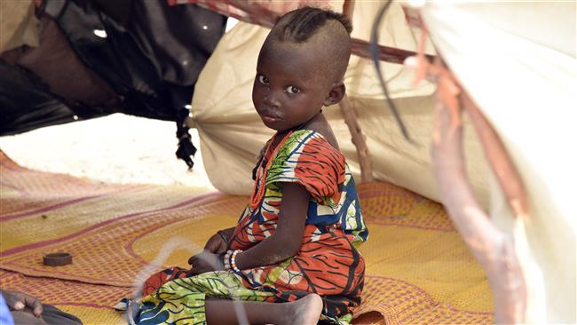 A child looks on under a makeshift tent in a camp in the village of Kidjendi near Diffa Niger