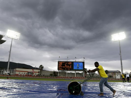 Ground staff dry the wicket under a stormy sky as rain delays day three of the second cricket Test match between India and West Indies at the Sabina Park Cricket Ground in Kingston Jamaica Monday Aug. 1 2016. The Jamaica Meteorological Service advised