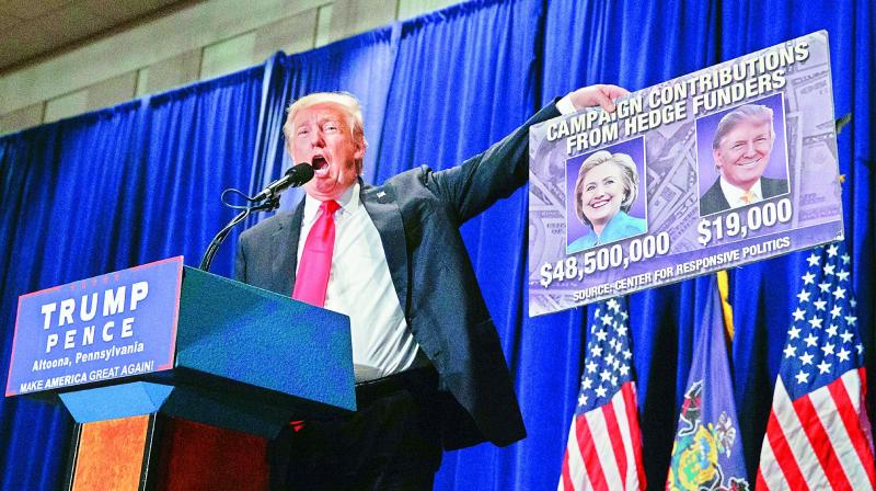 Republican presidential candidate Donald Trump holds up a sign during a campaign rally Saturday in Altoona