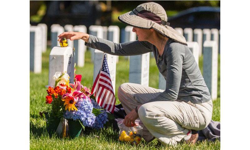 Alison Malachowski tends to the grave of her son U.S. Marine Corps Staff Sgt. James Malachowski in Section 60 of Arlington National Cemetery