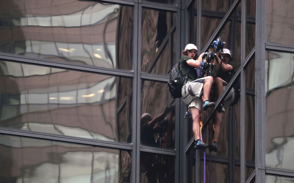 A man scales the all-glass facade of Trump Tower using suction cups Wednesday Aug. 10 2016 in New York. A police spokeswoman says officers responded to Donald Trump's namesake skyscraper on Fifth Avenue in Manhattan. The 58-story building is headq