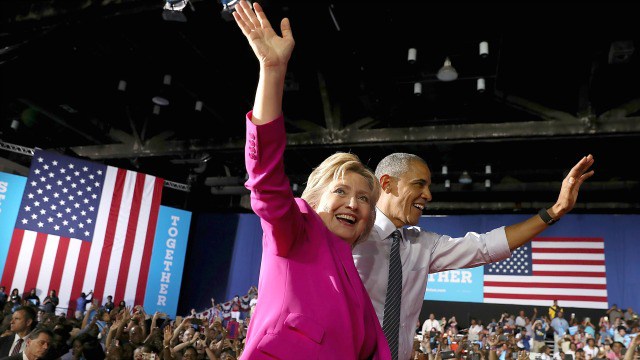 Democratic presidential candidate and former Secretary of State Hillary Clinton looks on as U.S. president Barack Obama speaks during a campaign rally