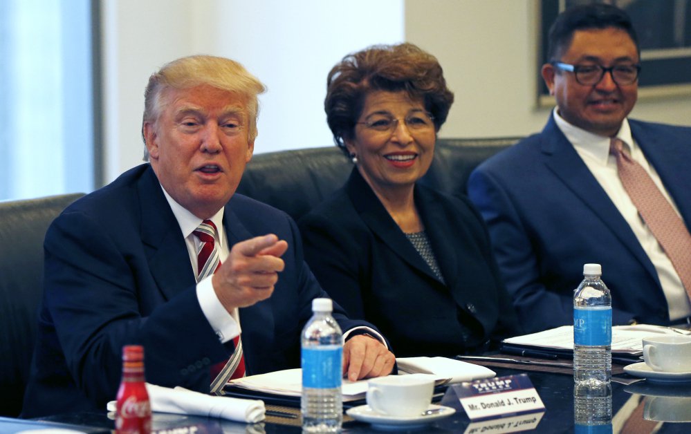 Republican presidential candidate Donald Trump holds a Hispanic advisory meeting in New York on Saturday. With him are Jovita Carranza former Small Business Administration deputy administrator and Joseph Guzman president of the American Society of Hisp