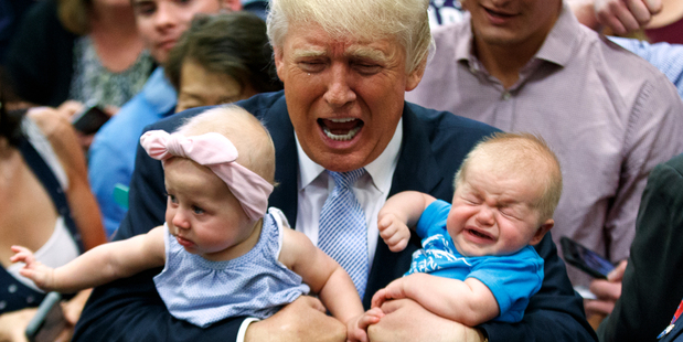 Republican presidential candidate Donald Trump holds Kellen Campbell of Denver right and Evelyn Keane of Castle Rock Colorado during a campaign rally