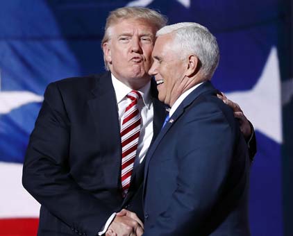 Republican presidential Candidate Donald Trump gives his running mate Republican vice presidential nominee Gov. Mike Pence of Indiana a kiss as they shake hands after Pence's acceptance speech during the third day session of the Republican National