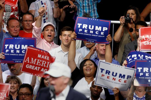 People cheer as Republican presidential nominee Donald Trump speaks on a stage during a campaign event in Dimondale Michigan on Friday