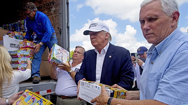 Donald Trump and his running mate Indiana Gov. Mike Pence right help to unload supplies for flood victims during a tour of the flood damaged area in Gonzales La. Friday