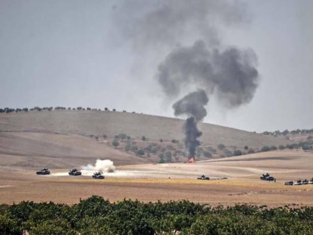 Turkish army tanks and pro Ankara Syrian opposition fighter trucks positioned two kilometres west from the Syrian Turkish border town of Jarabulus