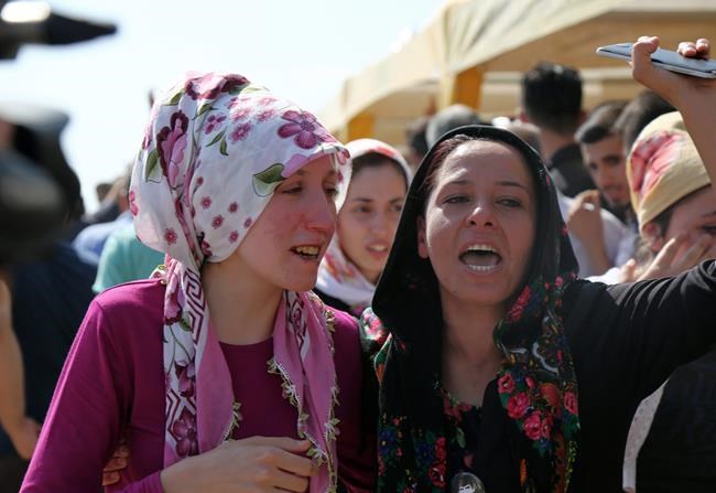 People mourn as they attend funeral services for dozens of people killed in last night's bomb attack targeting an outdoor wedding party in Gaziantep southeastern Turkey Sunday Aug. 21 2016. Deputy Prime Minister Mehmet Simsek said the'barbaric