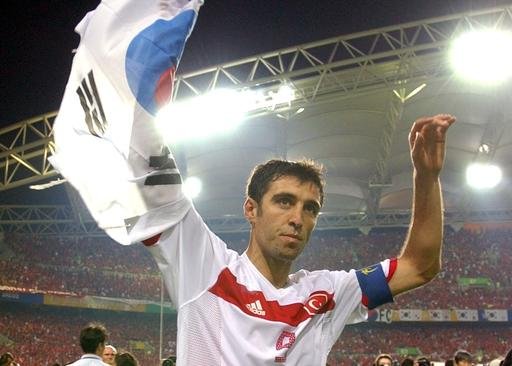 Turkey's Hakan Sukur holds a South Korean flag at the end of the 2002 World Cup third place playoff soccer match between South Korea and Turkey at the Daegu World Cup stadium in Daegu South Korea. Tu