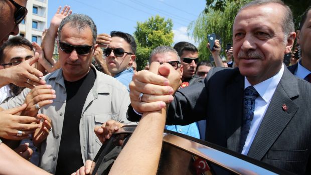 Turkey's President Recep Tayyip Erdogan shakes hands with supporters outside the Osmanli mosque in Ankara on Thursday