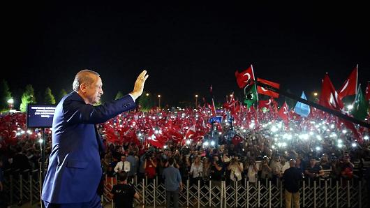 Turkish President Recep Tayyip Erdogan greets the people gathering at the Presidential Complex to protest July 15 failed military coup attempt before addressing them in Ankara Turkey