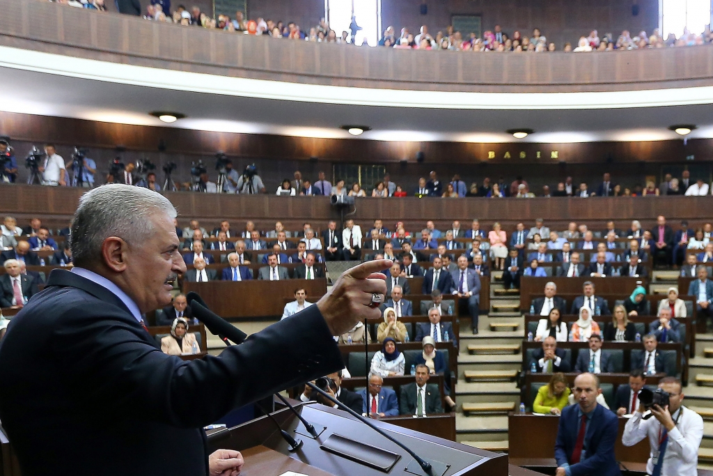 Turkey's Prime Minister Binali Yildirim left addresses in the Parliament in Ankara Turkey on Tuesday Aug. 2 2016. Yildirim announced plans Tuesday to shut down two military high courts _ the administrative and appeals and said military courts