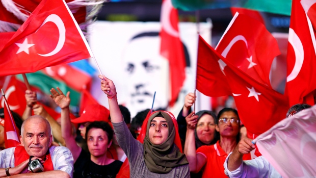 Supporters of Turkish President Recep Tayyip Erdogan wave national flags as they listen to him through a giant screen in Istanbul's Taksim Square on Aug. 10. The country has come down hard on perceived dissidents since a thwarted coup attempt last mon