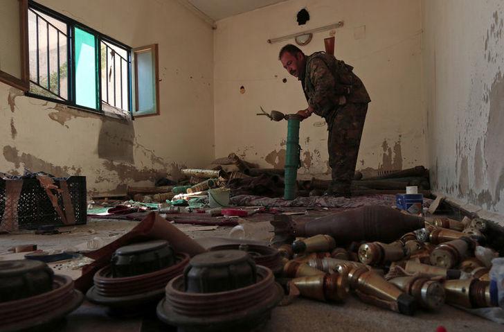 A Syria Democratic Forces fighter inspects a room which according to the SDF was used by Islamic State militants to prepare explosives in Manbij Aleppo Governorate Syria