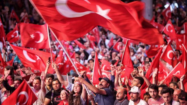 Supporters of Turkish President Tayyip Erdogan wave Turkish flags as they gather in Istanbul's central Taksim Square