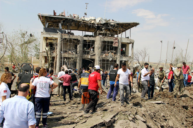 Soldiers medics rescue teams and officials work at the blast scene where two officers and one civilian were killed when a car bomb exploded outside a police station near the southeastern city of Diyarbakir Turkey. — Reuters