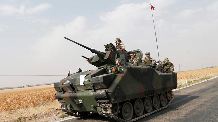 Turkish soldiers head to the Syrian border with tanks and vehicles as they prepare for a military operation against the so-called Islamic State