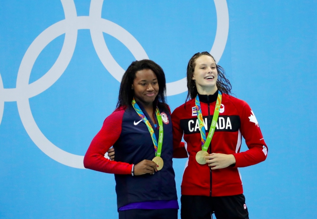 Joint winners United States Simone Manuel left and Canada's Penny Oleksiak celebrate with their gold medals after the women's 100-meter freestyle during the swimming competitions at the 2016 Summer Olympics Friday Aug. 12 2016 in Rio de Janeiro Br