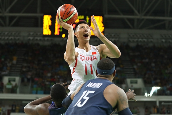 Chinese forward Yi Jianlian shoots over Carmelo Anthony and Draymond Green of Team USA