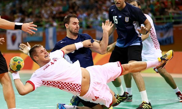 RIO DE JANEIRO BRAZIL- AUGUST 09 Kresimir Kozina #44 of Croatia is tripped up by Pablo Portela #5 and Gonzalo Carou #15 of Argentina on Day 4 of the Rio 2016 Olympic Games at the Future Arena