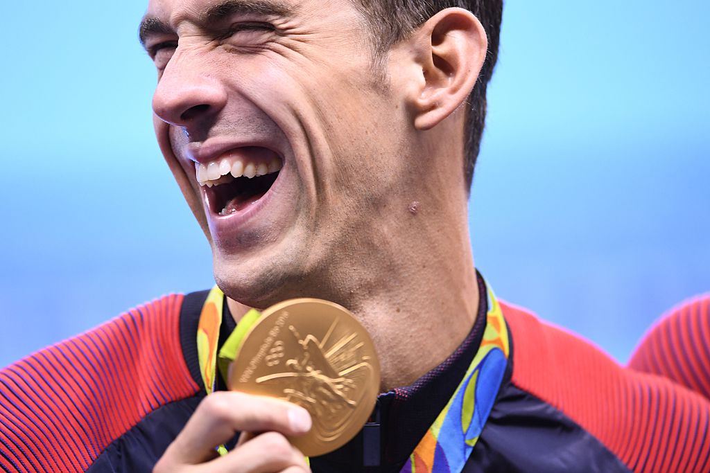 Michael Phelps poses with his gold medal during the podium ceremony of the Men's swimming 4 x 100m Medley Relay Final at the Rio 2016 Olympic Games