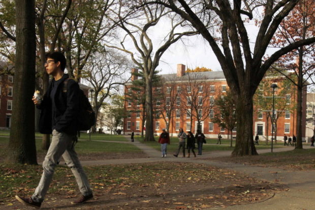 A man walks through Harvard Yard at Harvard University in Cambridge Massachusetts