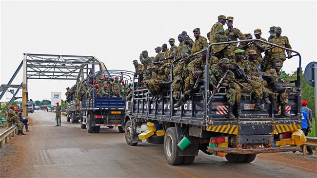 Ugandan military personnel are seen atop military and police trucks as they drive toward Juba in South Sudan at Nimule border point