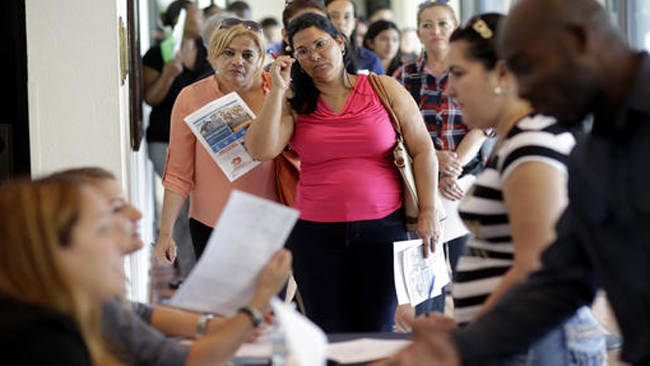 Reina Borges left stands in line to apply for a job with Aldi at a job fair in Miami Lakes Fla. On Friday Aug. 5 the Labor Department issues its jobs report for July