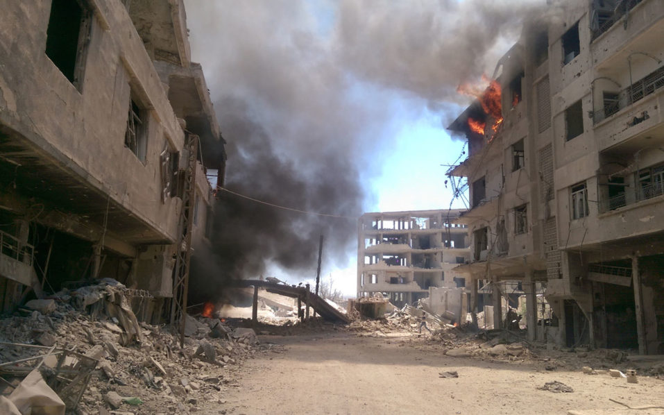 Fire and smoke gush out of buildings following reported air strikes on the Syrian besieged rebel-held town of ?Daraya near the capital Damascus